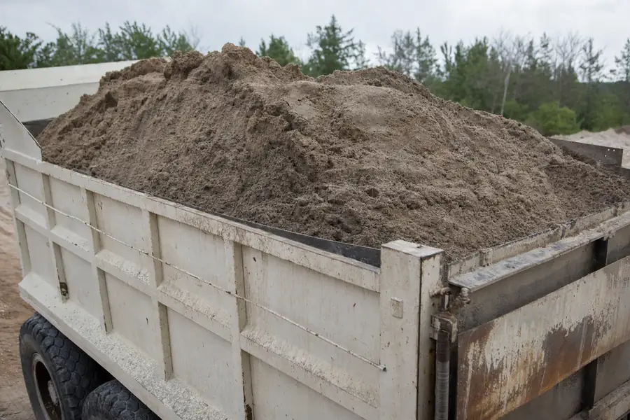 Dump truck bed loaded with wet sand ready for weighed delivery