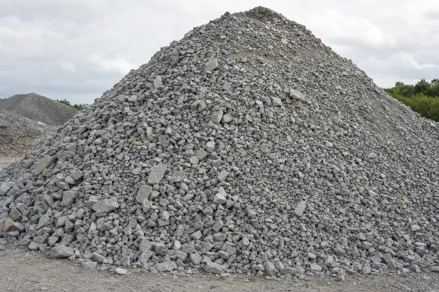 Pile of crushed concrete aggregate with angular gray fragments at a supply yard