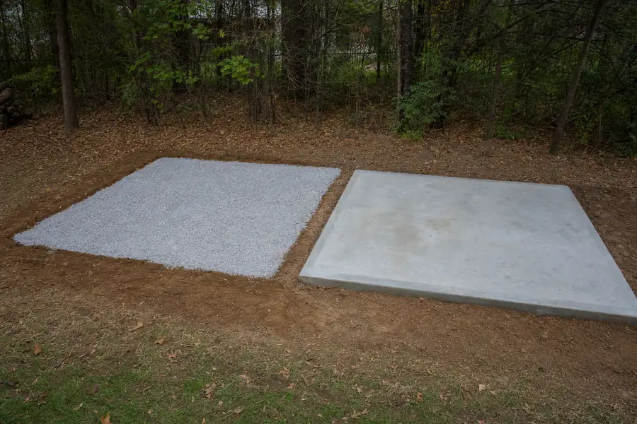 Side-by-side comparison of a compacted gravel pad and a poured concrete slab for a shed